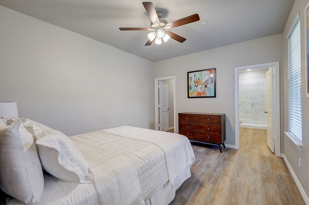 Willow Park Townhomes - Willow Crossing - An interior shot of the bedroom with a large bed and a ceiling fan
