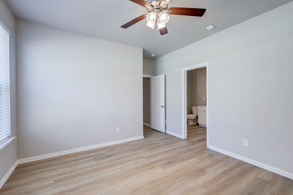 an empty living room with white walls and a ceiling fan