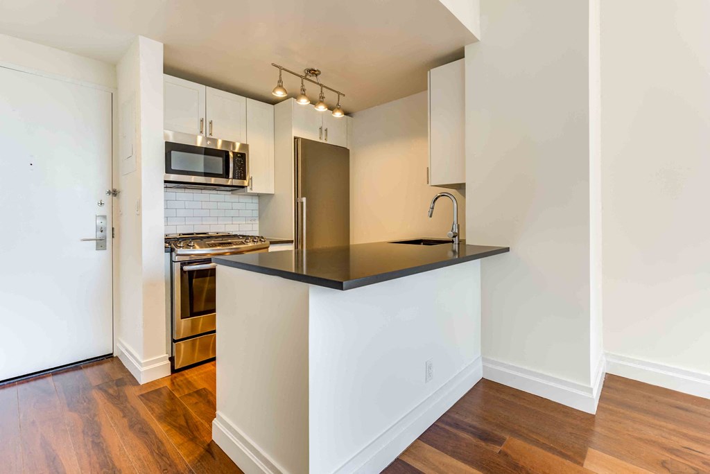a kitchen with a counter top and a stove and a refrigerator