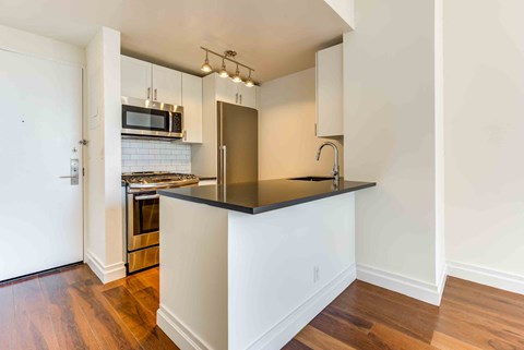 a kitchen with a counter top and a stove and a refrigerator