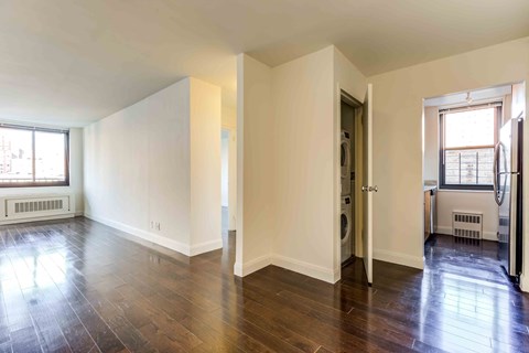 an empty living room with white walls and wood floors
