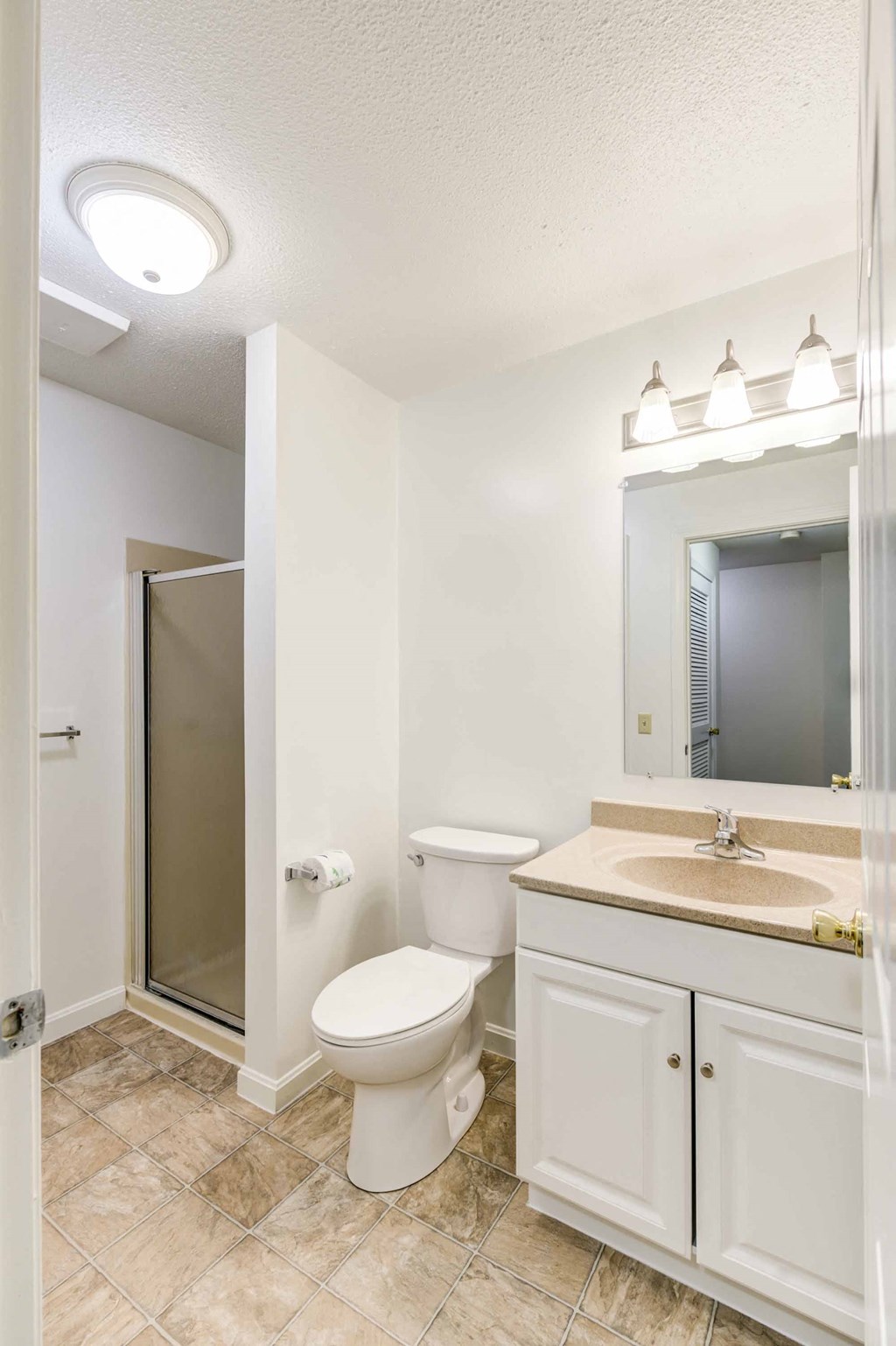 bathroom with standing shower and white vanity