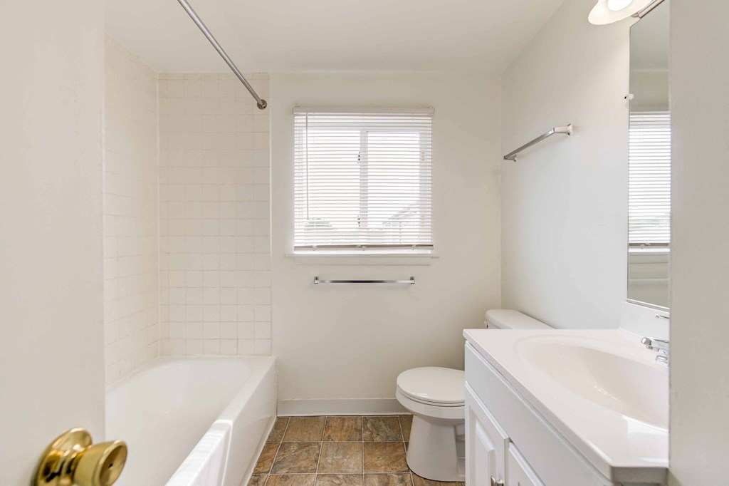 bathroom with tub and white vanity