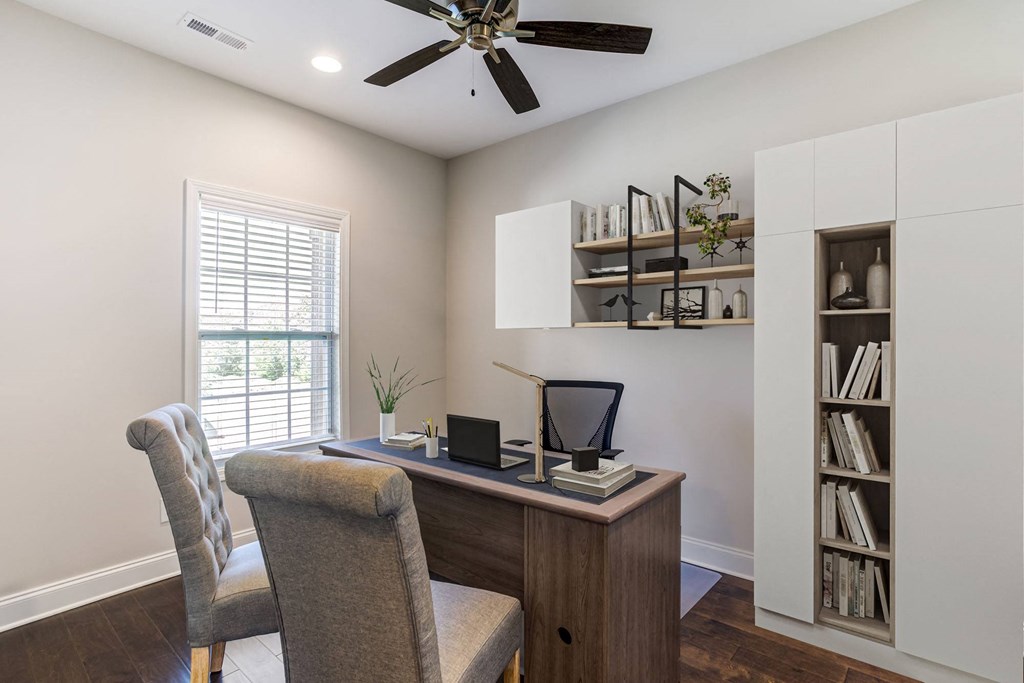 a home office with a desk and a ceiling fan