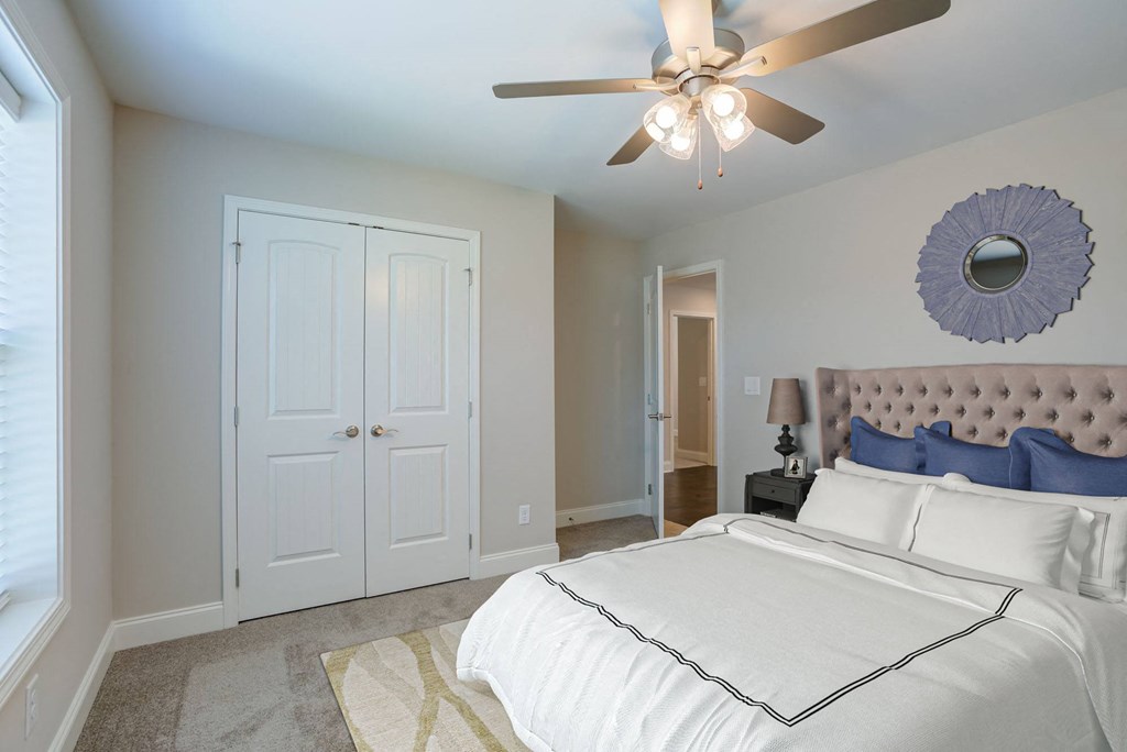 a bedroom with a large bed and a ceiling fan