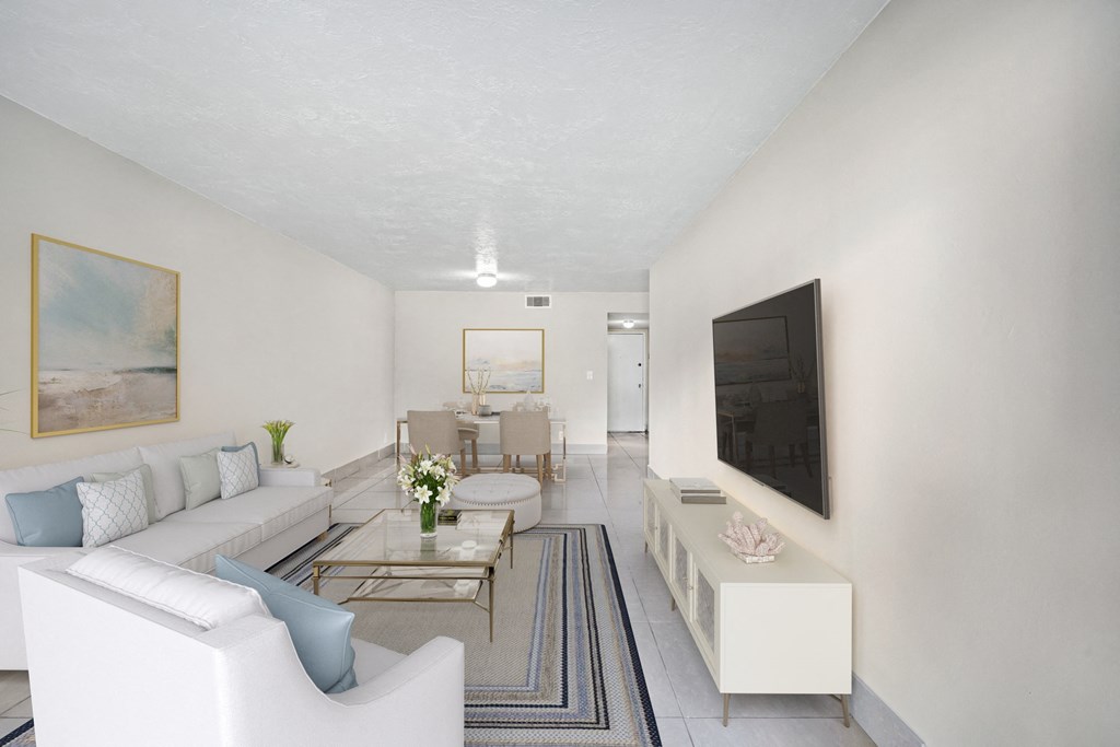 Windward vista apartments in Lauderhill, FL photo of a living room with a white couch and a television and tile flooring