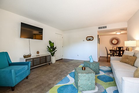 A living room with a blue chair and a white couch.