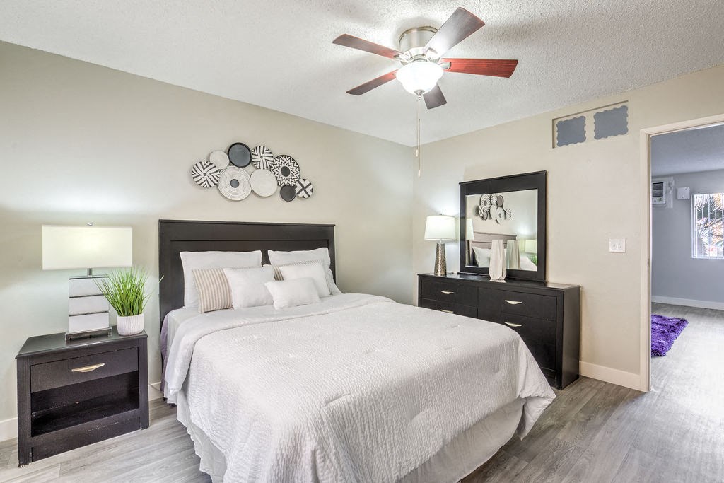 a bedroom with a large bed and a ceiling fan