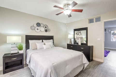 a bedroom with a large bed and a ceiling fan