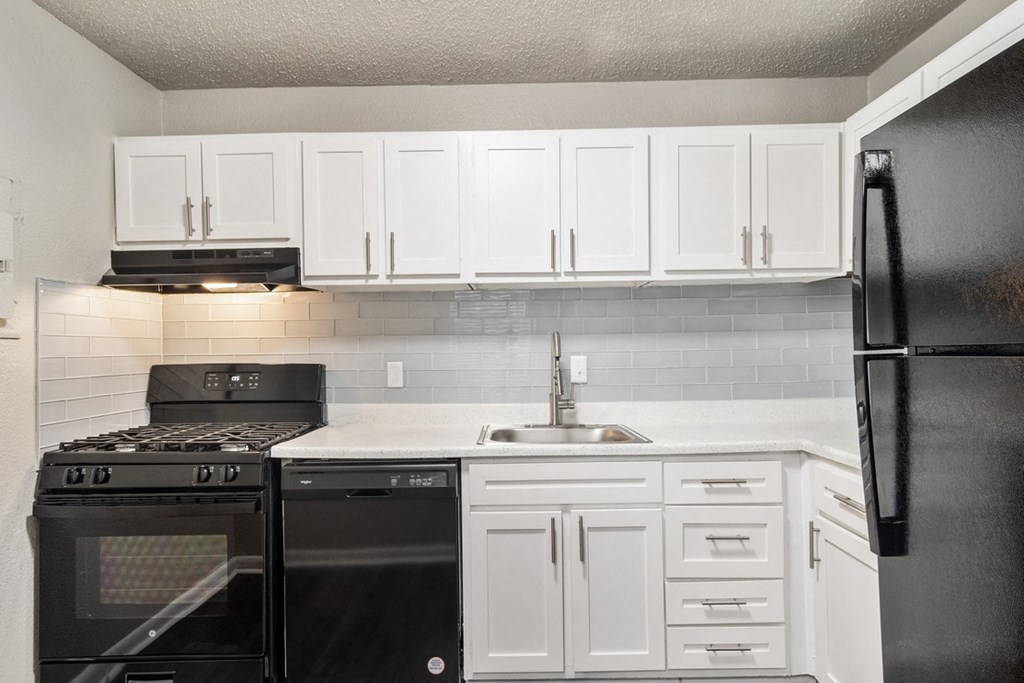 Kitchen with black appliances and white cabinets at Wyndcliff Galleria in Smyrna, GA.