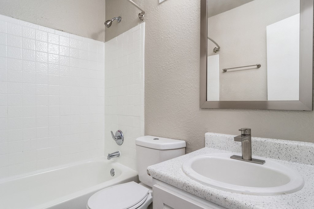Bathroom at Wyndcliff Galleria in Smyrna, GA, featuring a tub with shower and a vanity mirror above the sink.