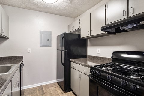 a kitchen with stainless steel appliances and a black refrigerator