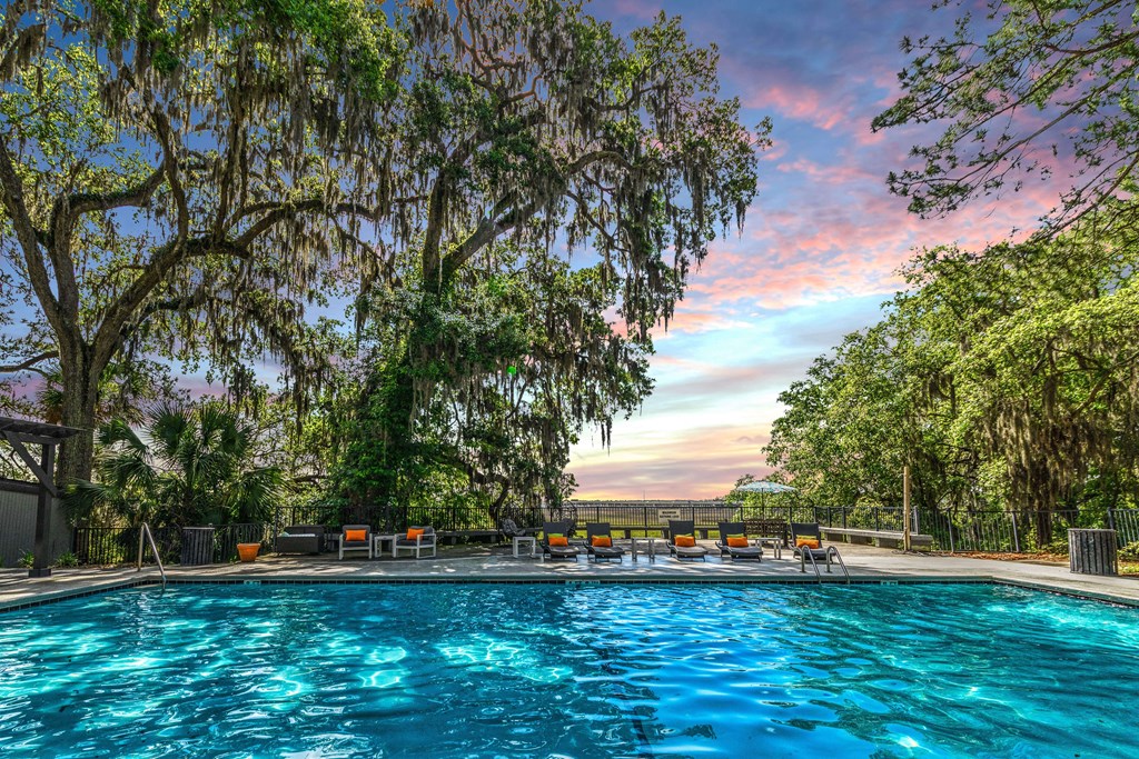 a swimming pool with a colorful sky in the background
