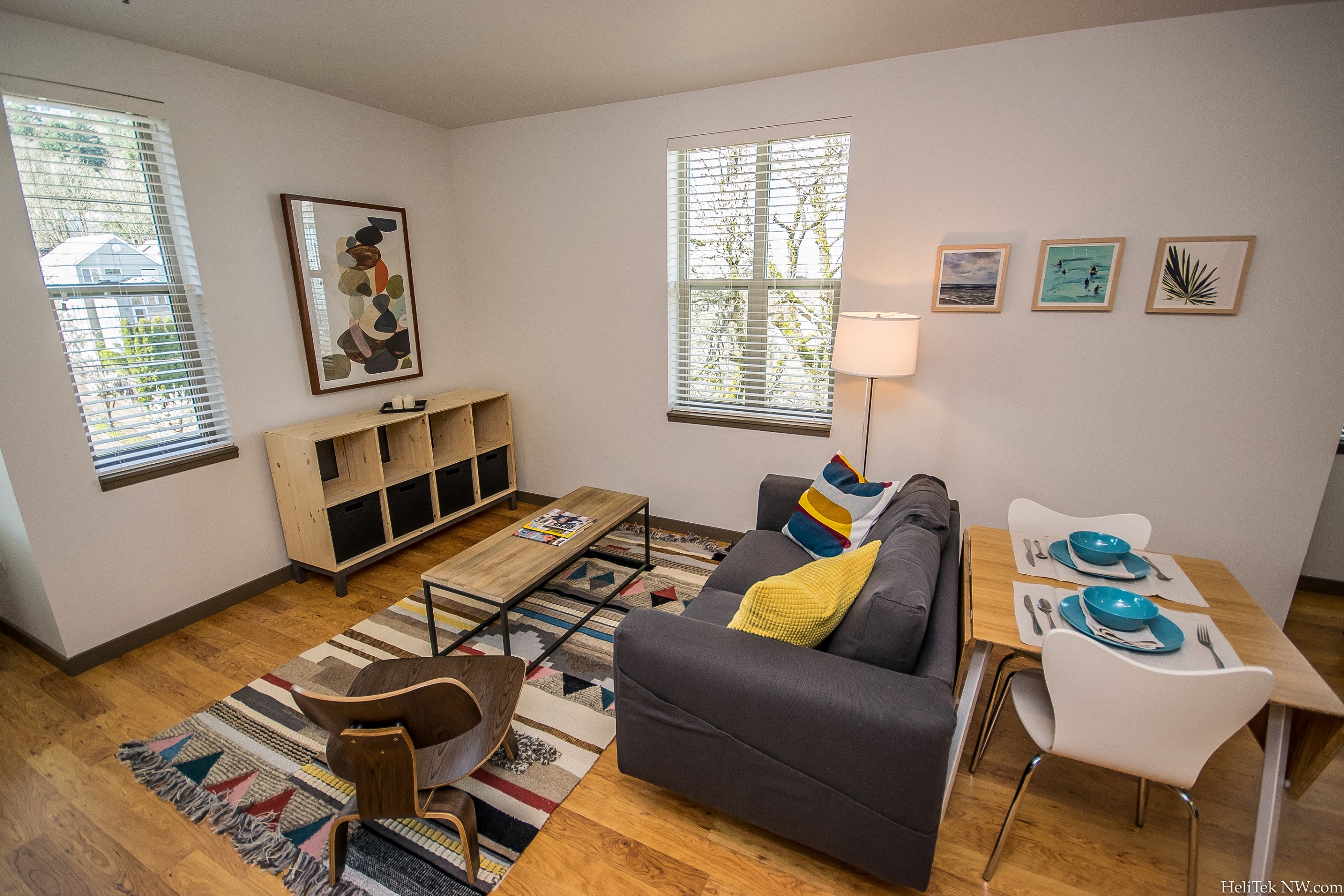 Apartments in Portland, OR - Corbett Heights - Living Room with Hardwood Flooring, Stylish Decor, Couch, Table and Chairs, Windows, and Outdoor Patio Access