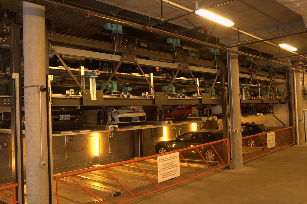 a parking garage with cars in it and a sign in front of it