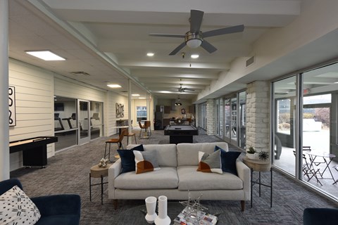 A living room with a white couch and a ceiling fan.