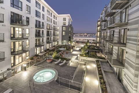 A rooftop patio with a hot tub and a view of the water.