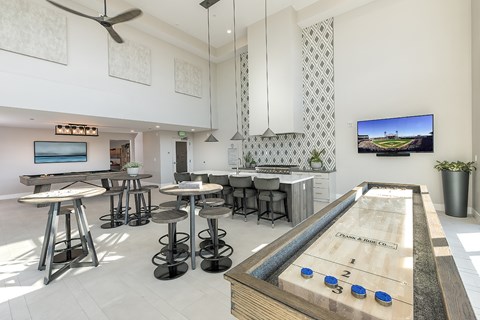 A shiny pool table with blue balls numbered 1-5 is in the middle of a room with a TV on the wall.