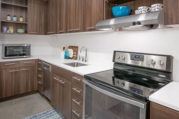 a kitchen with white countertops and stainless steel appliances