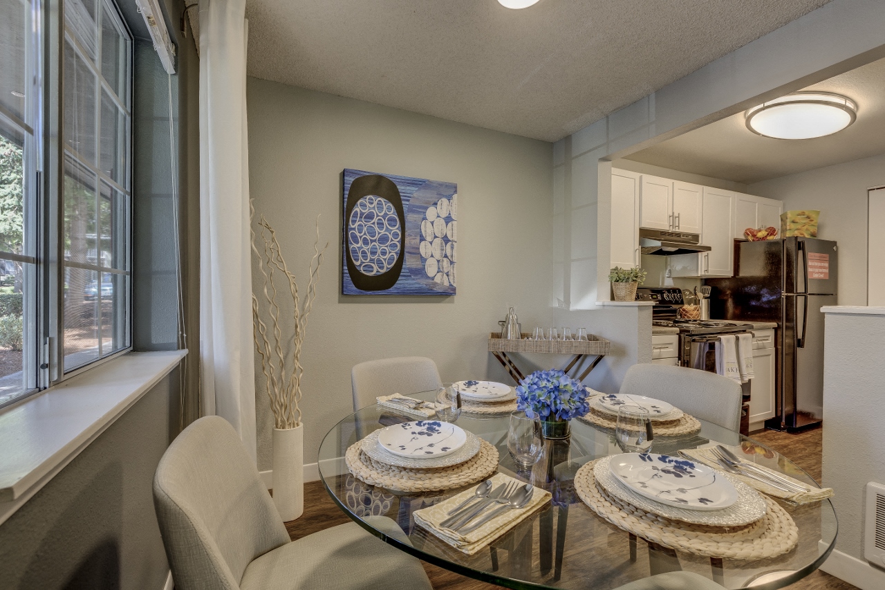 Beaverton OR Apartments - Cedar Crest - Dining Room with Glass Table and Grey Walls Leading into the Kitchen