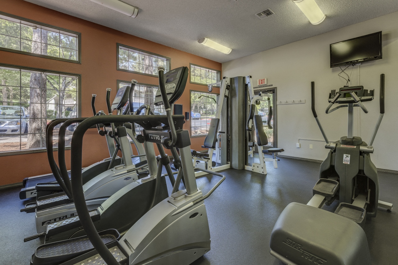 Apartments in Beaverton, OR for Rent - Cedar Crest - Gym with Window, a TV, and Cardio Equipment.