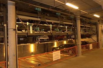 a parking garage with cars in it and a sign in front of it