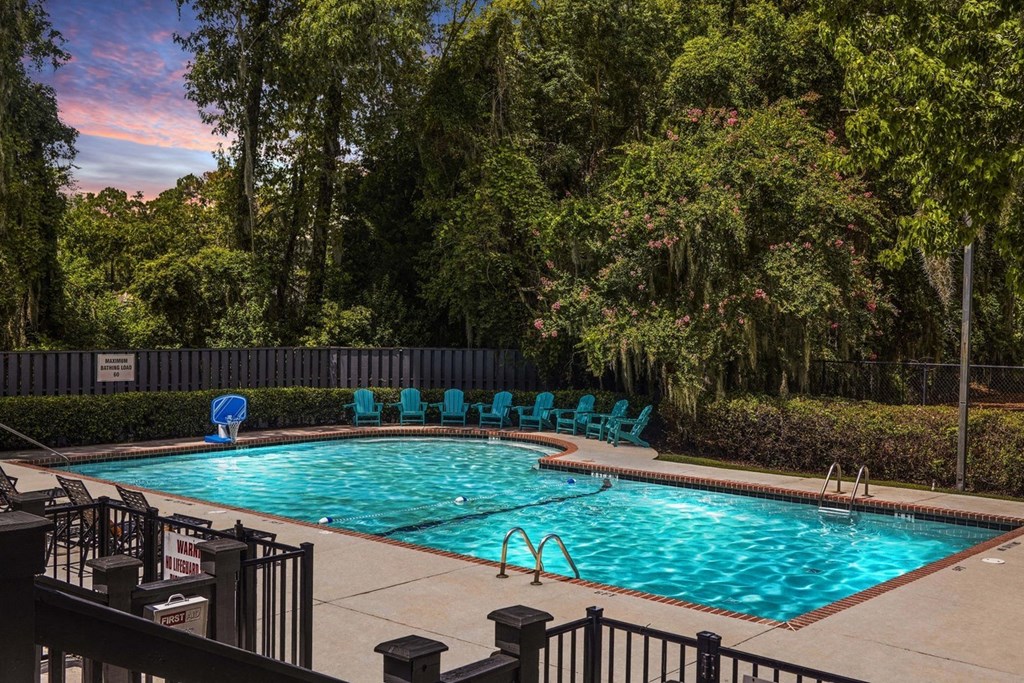 Greentree Apartments in Savannah, GA photo of a resort style swimming pool with blue chairs around it