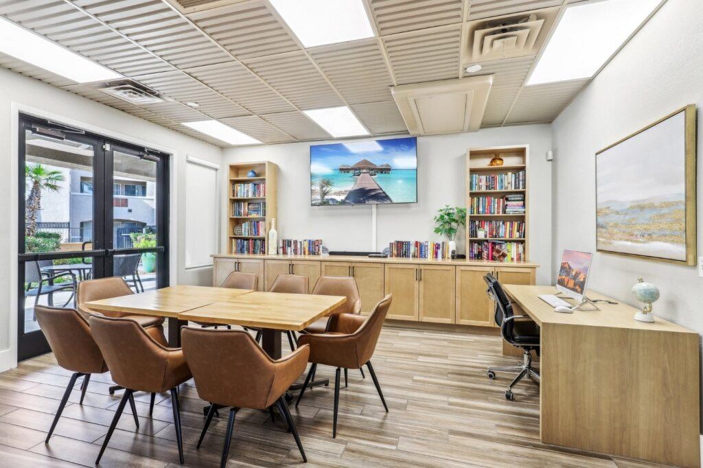 A conference room with a long table surrounded by chairs.