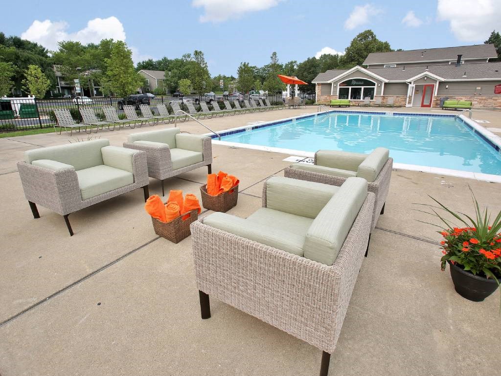 a swimming pool with chaise lounge chairs and potted plants