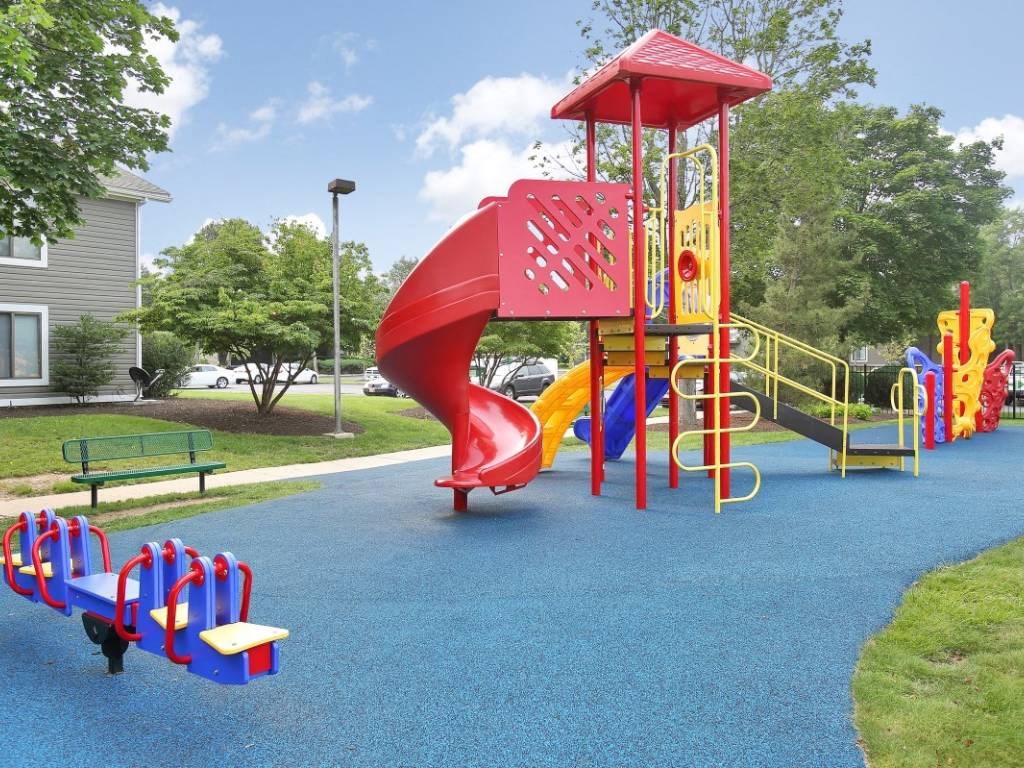 a playground with a red slide in a park