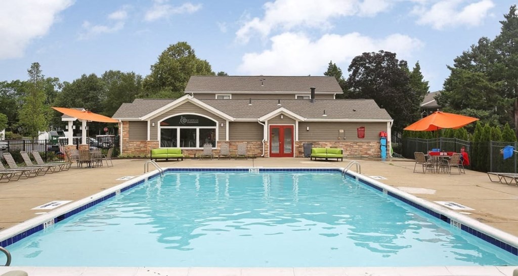 a swimming pool with a house in the background