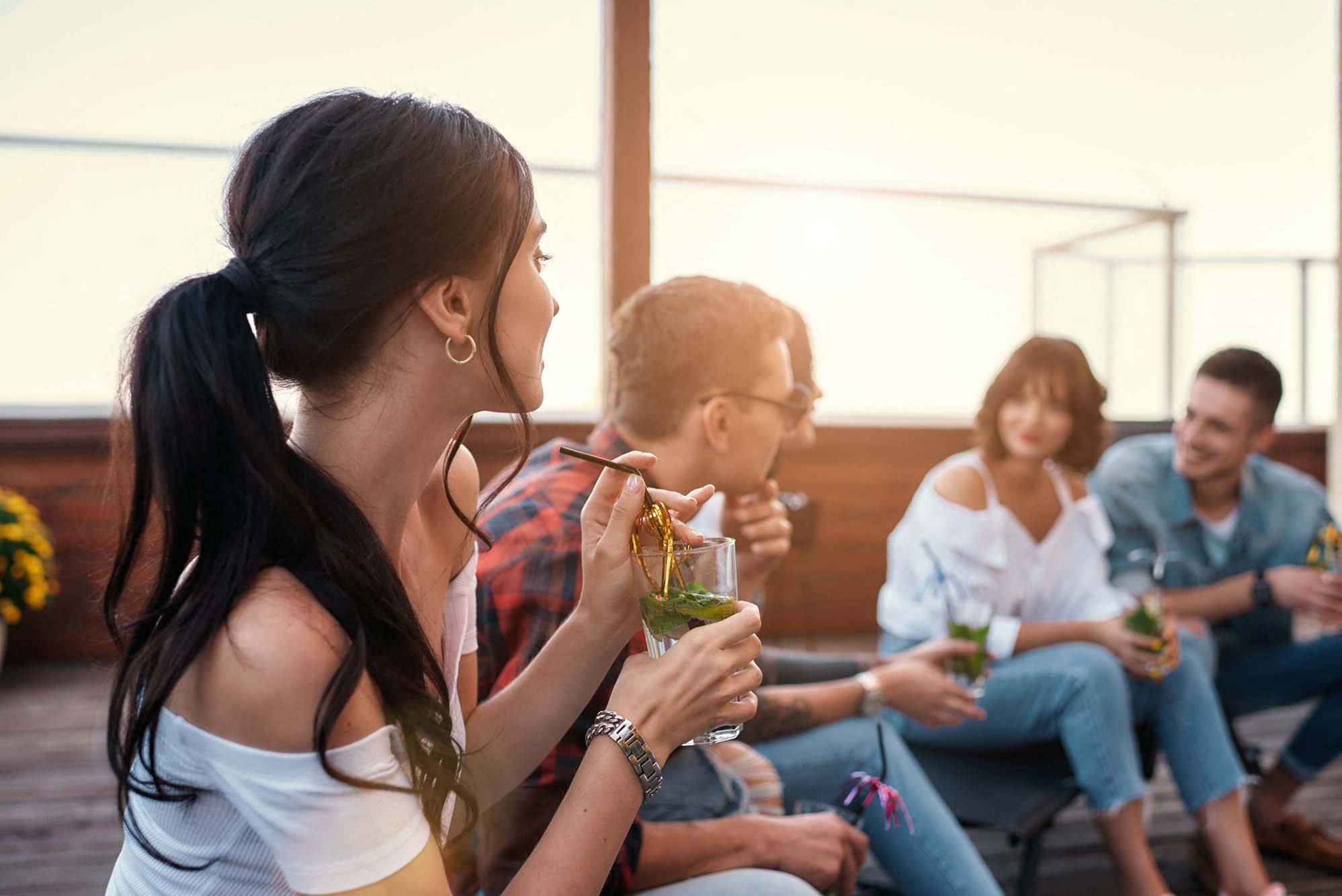 a group of people sitting around eating and drinking