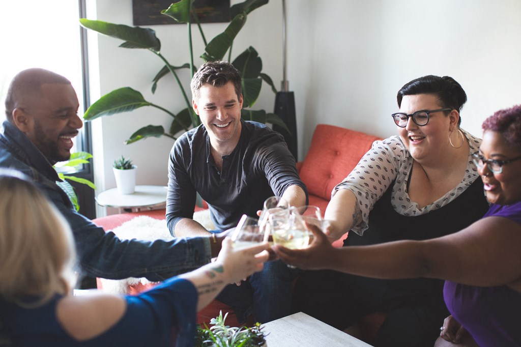 a group of people sitting around a table drinking wine