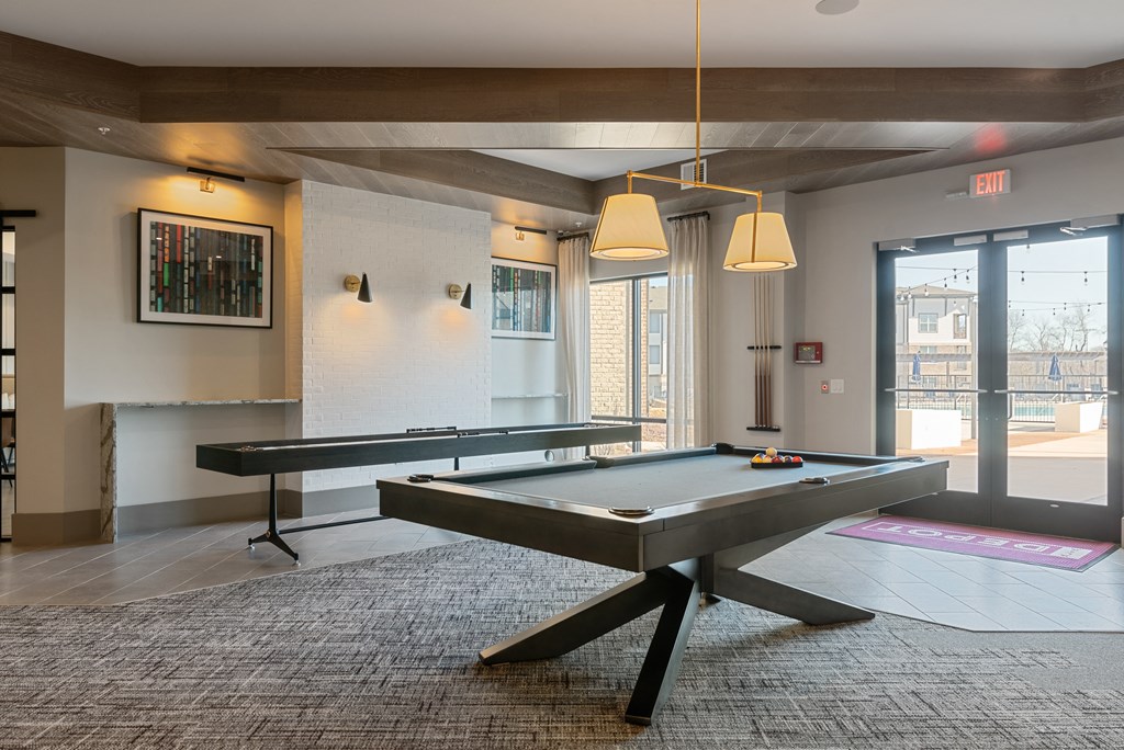 a ping pong table in the lobby of an office building with a pool table