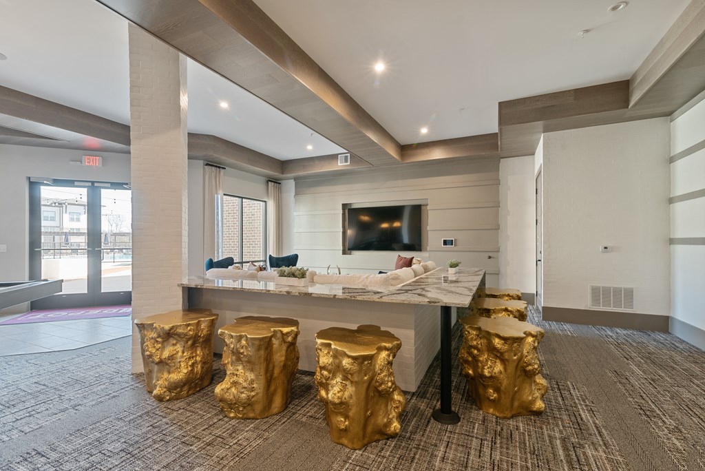 a gold seating area in a room with a bar and a television