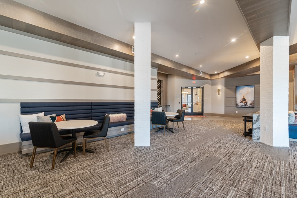 a large lobby with tables and chairs and a fireplace