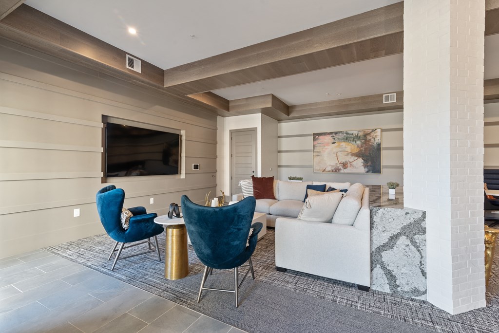 a living room with a couch and chairs and a television