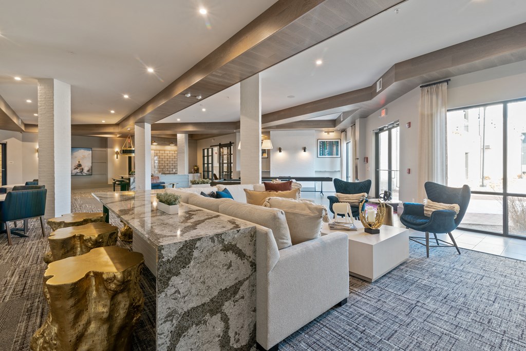 a living room with couches and chairs and a marble table
