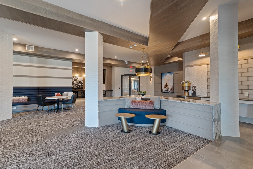 a lobby with a blue couch and a table with chairs