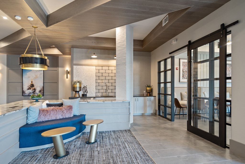 a living room with a blue couch and a kitchen in the background