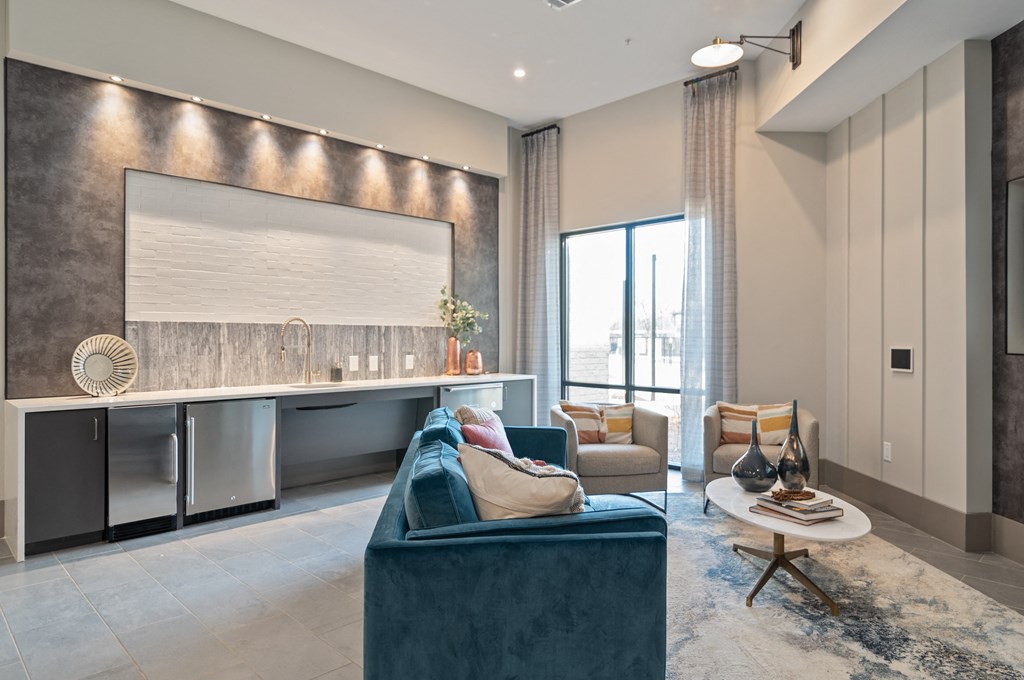 a living room with a blue couch and a kitchen