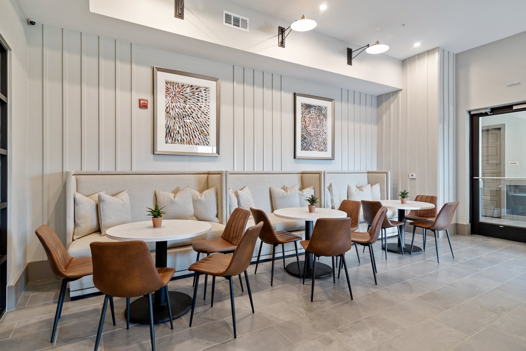 a dining room with tables and chairs in front of a white wall