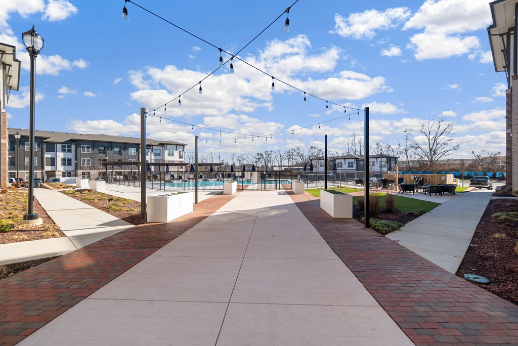 a walkway leading to a pool and a building with lights