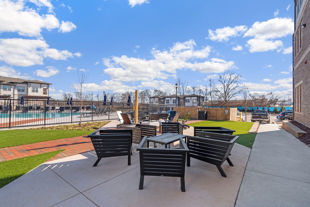 an outdoor patio with tables and chairs near a pool