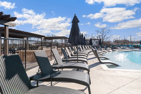 a row of lounge chairs next to a pool