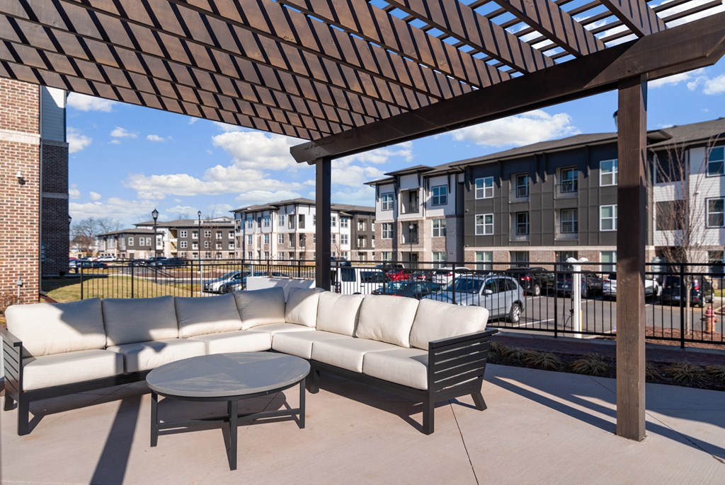 a patio with a couch and a table in front of a building