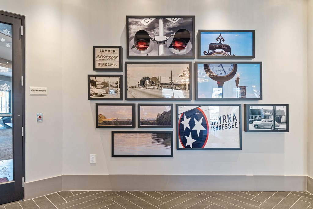 a wall of pictures in a room with a door