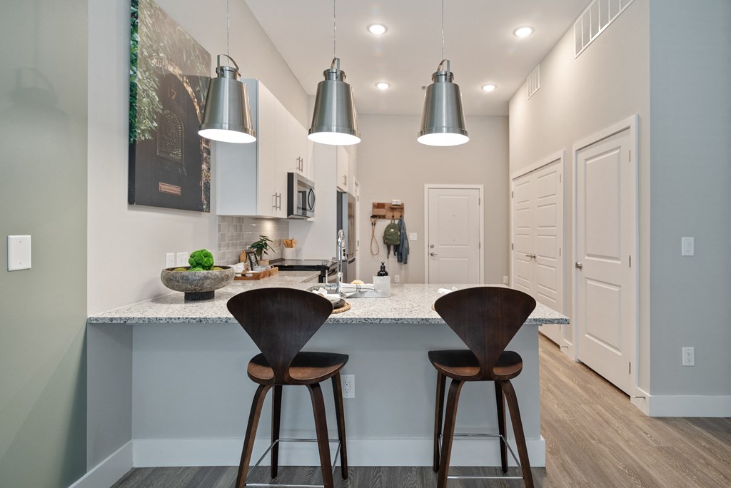 a kitchen with three stools in front of a counter top