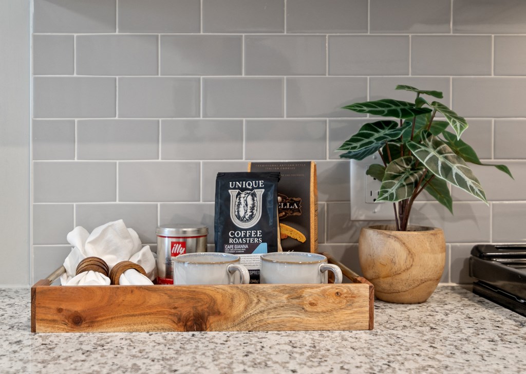 a wooden tray with coffee supplies on a kitchen counter