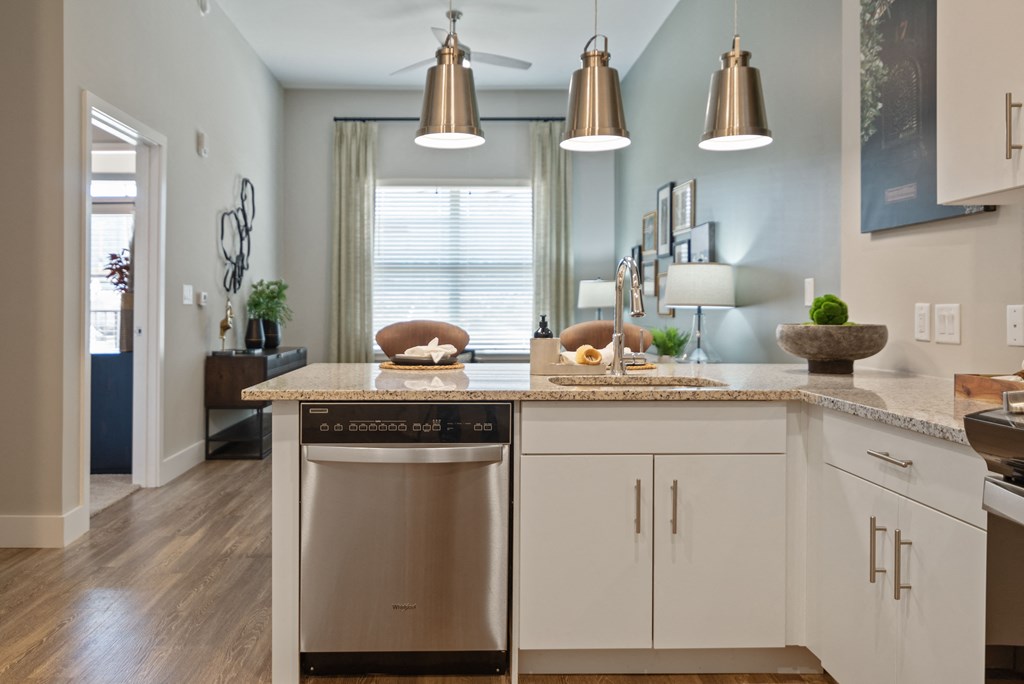 a kitchen with an island and stainless steel dishwasher in it